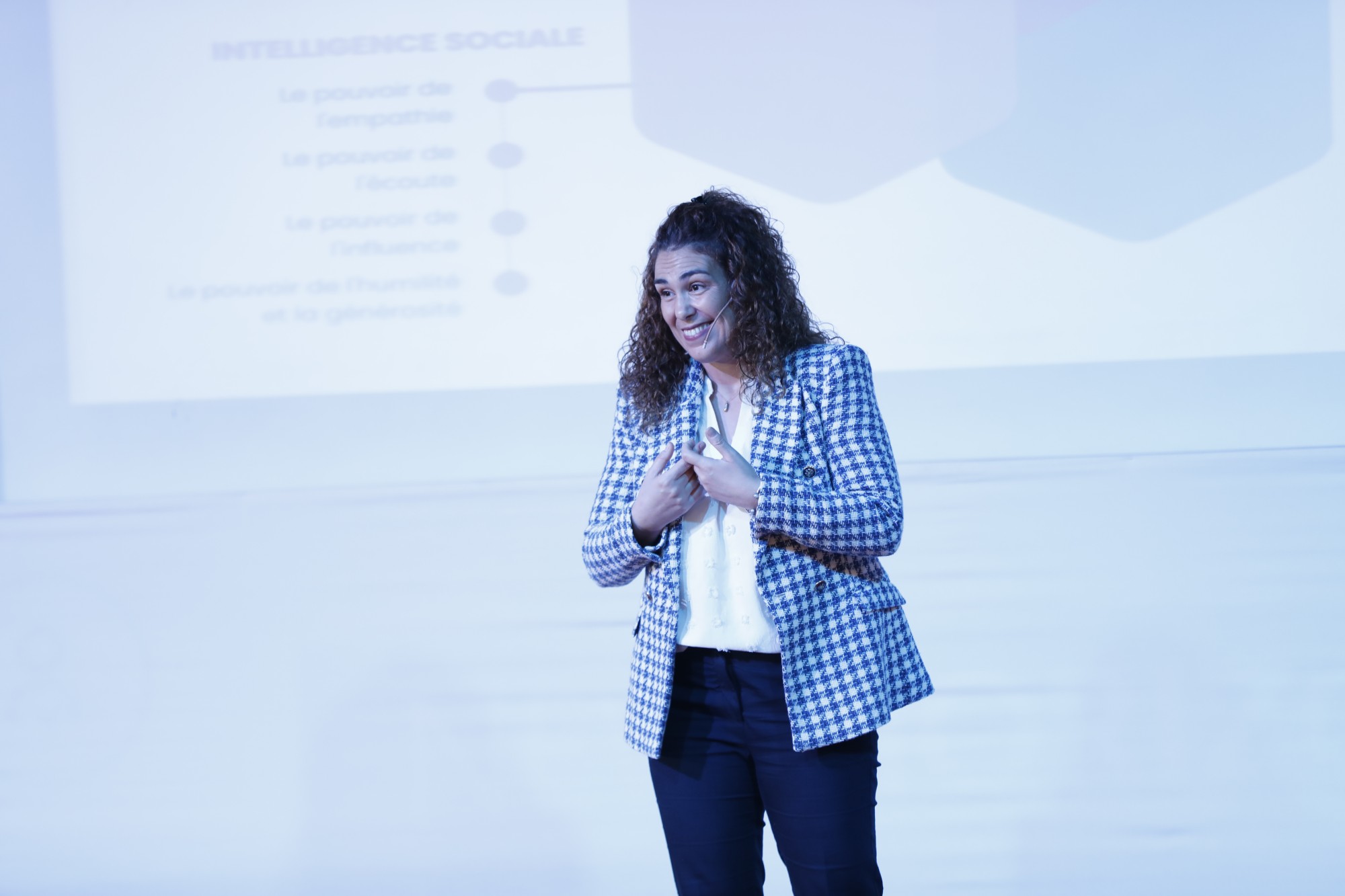 Intervenante souriante sur scène pendant le programme Leadership Impact